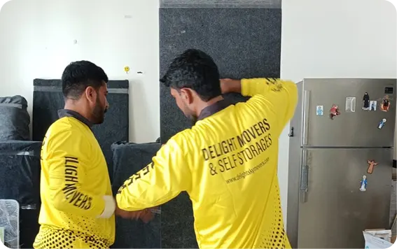 Delight movers carrying a fridge out of a 1BHK apartment in Dubai