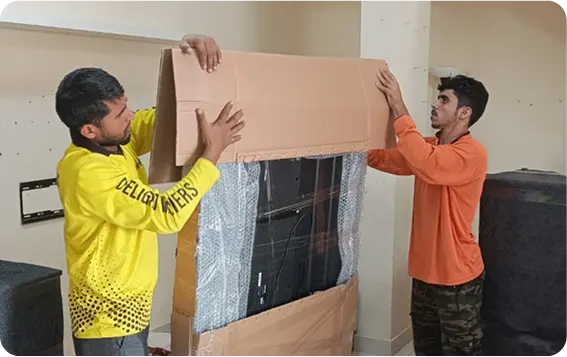 Movers crating a television for international shipping from Dubai