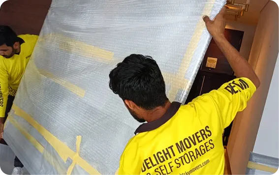 Mover wrapping furniture in export packing in Dubai