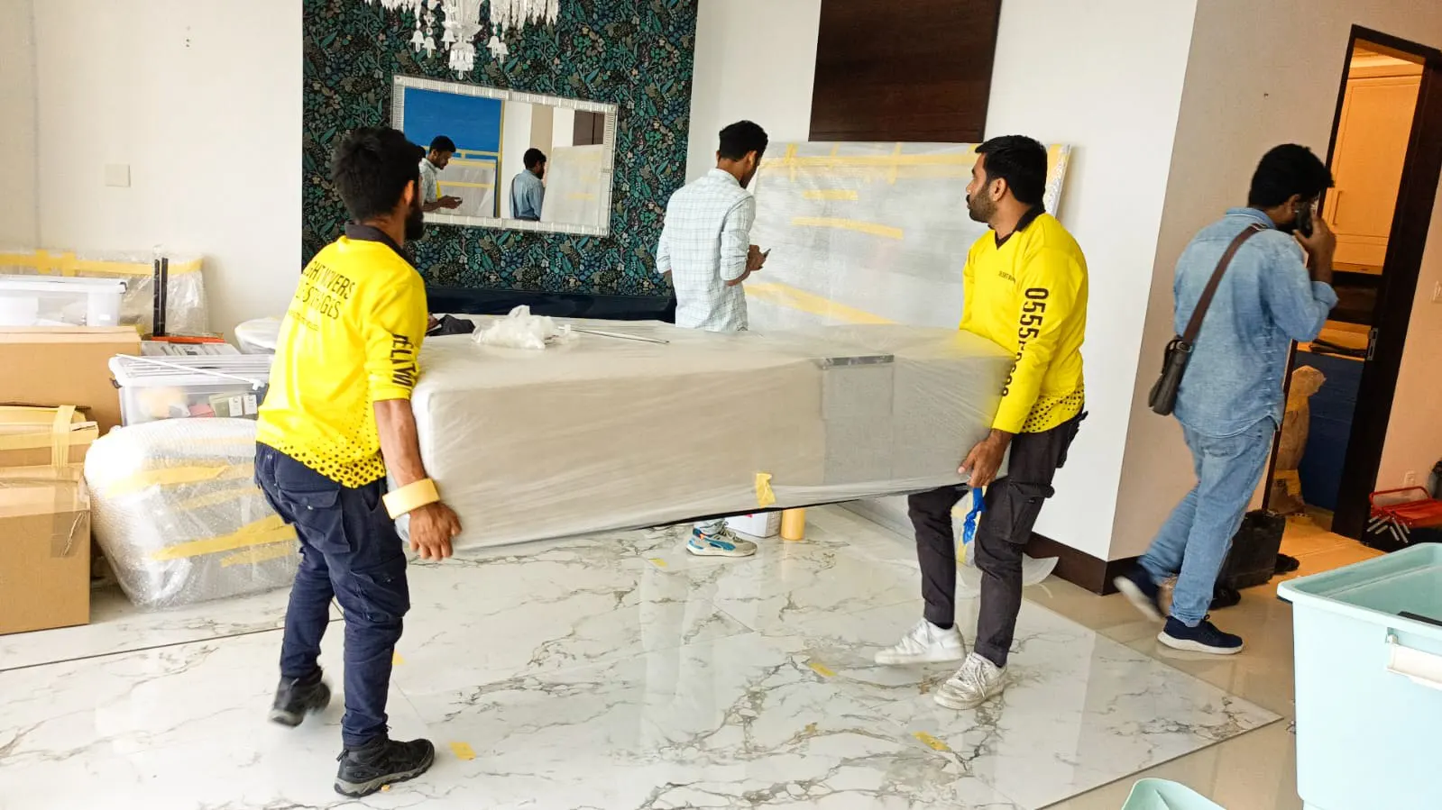 Movers carrying a glass dining table in a Palm Jumeirah home